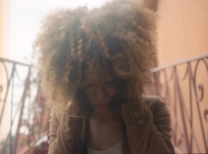 Young woman holding her head in sadness, reflecting the emotional and multifactorial nature of depression